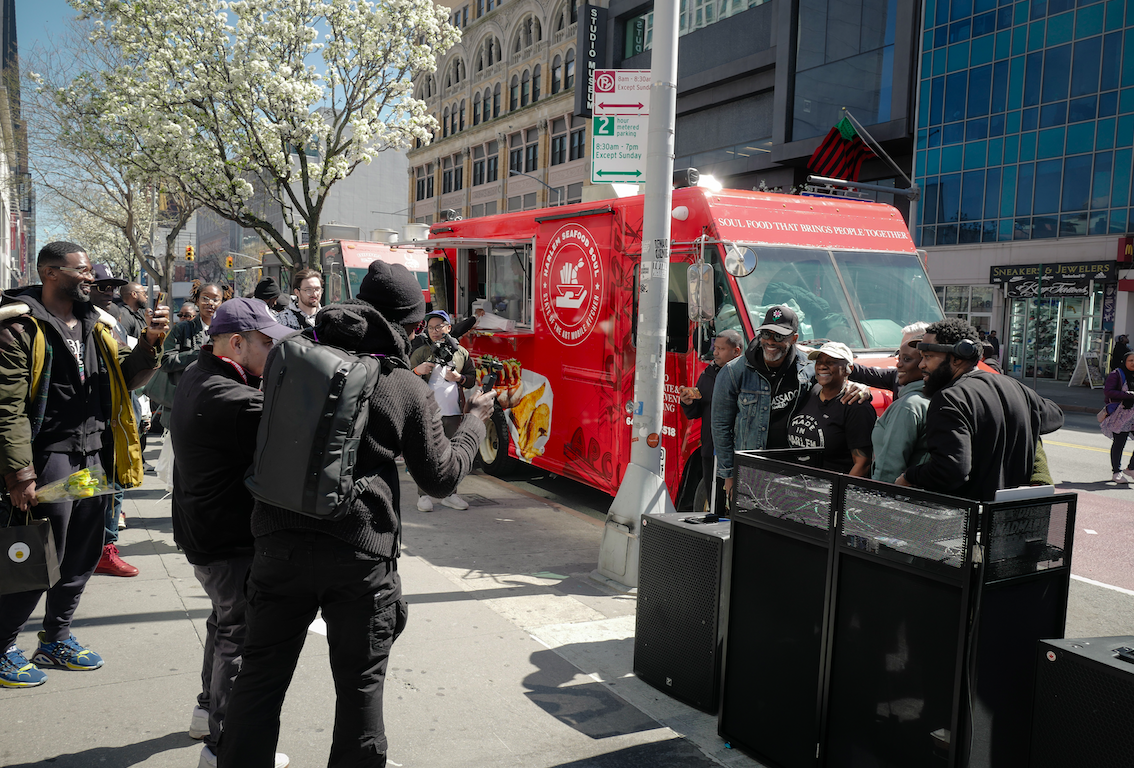 People standing around Harlem Seafood Soul food truck